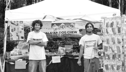 Founders of Himalayan Pet Supply standing in front of one of their first booths